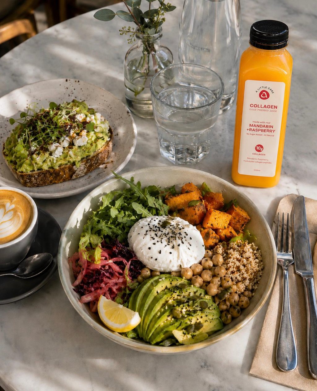 An A Little Care Mandarin and Raspberry collagen cold-pressed juice on a café table beside a nourish bowl and avocado toast.